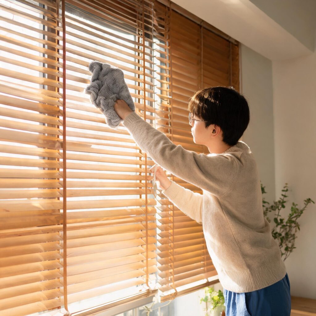 person-dusting-wooden-blinds-with-microfiber-clothfrom door&window factory